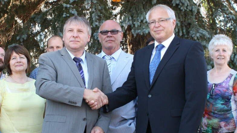 Die beiden Bürgermeister Gerd Barthold (links) und Tony Löffler reichen sich bei der Eröffnung des Ubstadt-Weiher-Platzes in Nünchritz im Juli 2011 die Hand.
