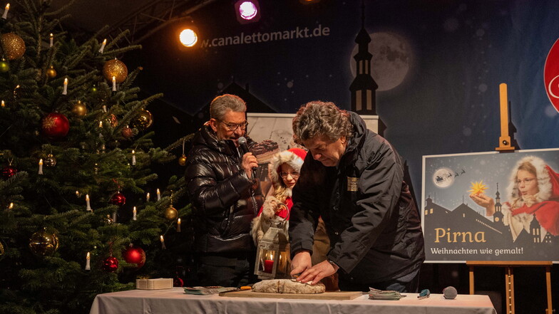 Stollenanschnitt zur Eröffnung: OB Klaus Peter Hanke (v.l.), Weihnachtskind Annika und Gerald Seifert von der Bäckerei Bärenhecke.