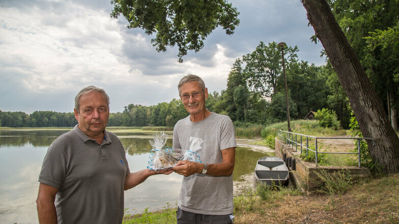 Ein symbolischer Fisch ist es, den Dietmar Mühle (links) an Rüdiger Richter übergibt. Künftig hat der Chef der Teichwirtschaft Kreba den Hut für die Organisation des Fischerfestes an der Schwarzen Lache auf.