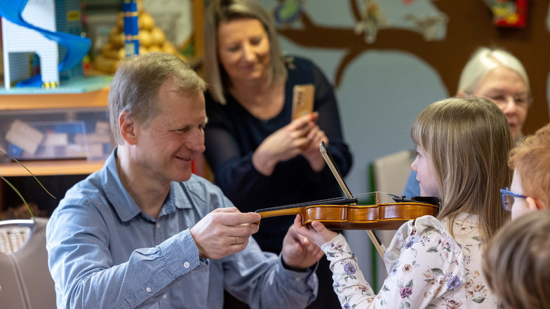 Die sechsjährige Mila übt mit Hilfe Thoralf Bredemann an der Geige.