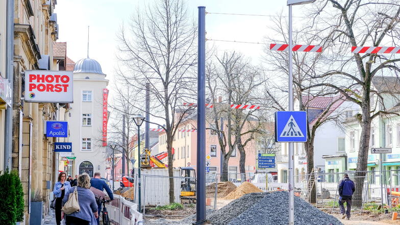 Mächtig gewaltig wirken die neuen Masten für die Straßenbeleuchtung im Zentrum von Radebeul-West. Zwischen diesen sind Drähte über die Fahrbahn gespannt.