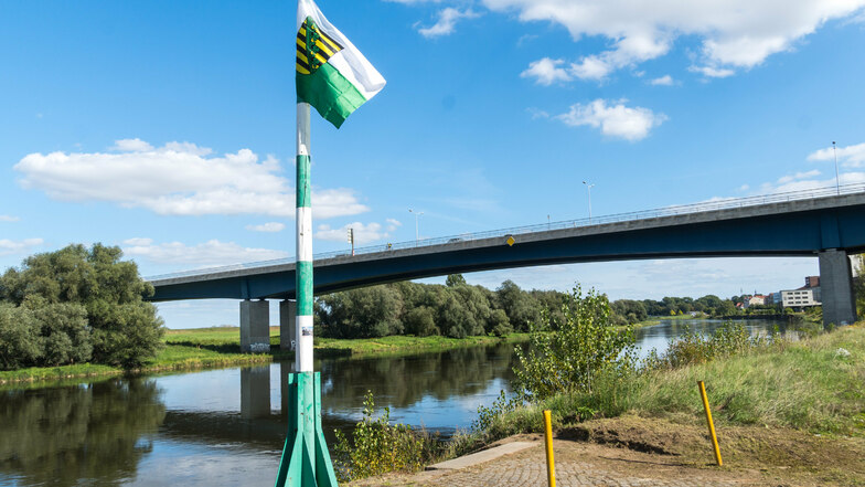 Windspiel am Elbufer: Zwischen Straßen- und Eisenbahnbrücke in Riesa weht seit einigen Tagen eine Sachsenflagge.