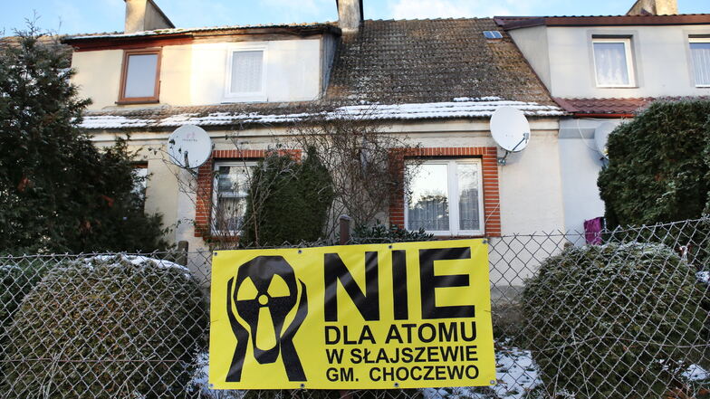 Ein Plakat mit der Aufschrift "Nein zum Atom" hängt an einem Zaun vor einem Haus in der Nähe des polnischen Dorfs Slajszewo.
