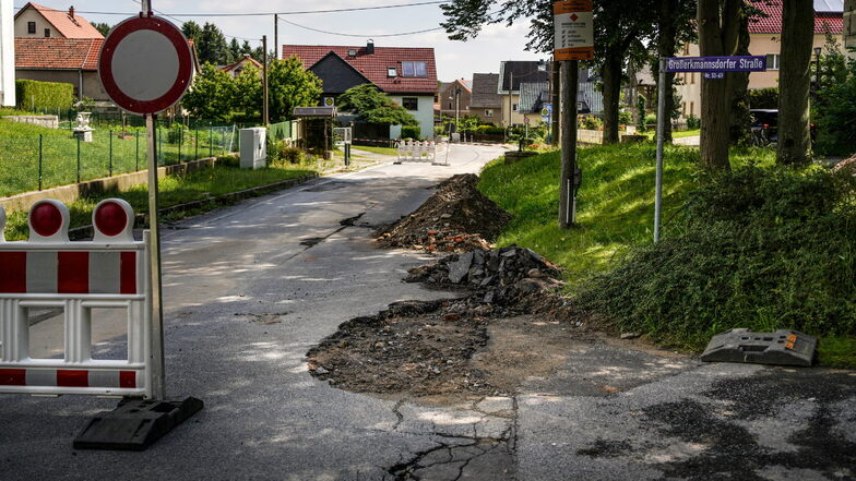 Starker Regen hat in Kleinwolmsdorf die Großerkmannsdorfer Straße so sehr beschädigt, dass sie voll gesperrt werden musste.