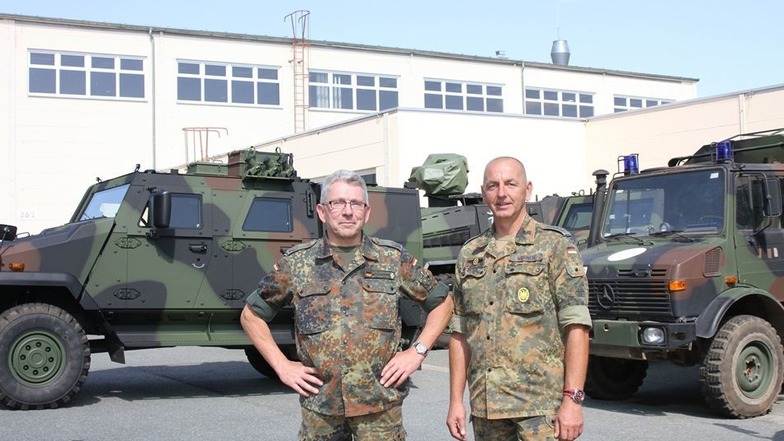 Oberstleutnant Wolfgang Möllenbrink (links) stattete Oberstabsfeldwebel Maik Werner, Leiter des Materiallagers Zeithain, am Mittwoch einen Dienstbesuch ab. Neufahrzeuge des Typs „Eagle V„ (links im Bild) werden seit Kurzem direkt vom Schweizer Hersteller 