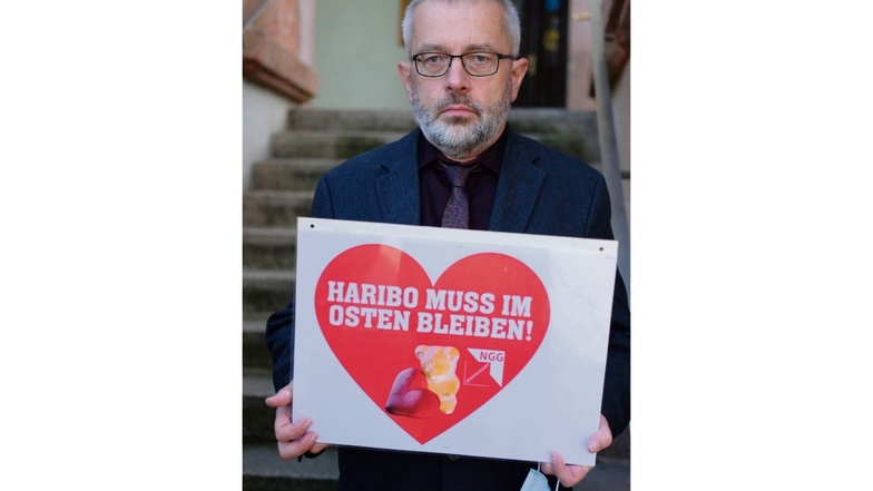 Stefan Feustel (CDU), Bürgermeister von Wilkau-Haßlau, hält ein Schild mit der Aufschrift "Haribo muss im Osten bleiben!".