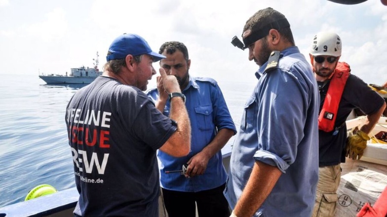 Der „Lifeline“-Kapitän erklärt und die Delegation der libyschen Küstenwache diskutieren die Situation der geretteten Schiffbrüchigen an Bord.