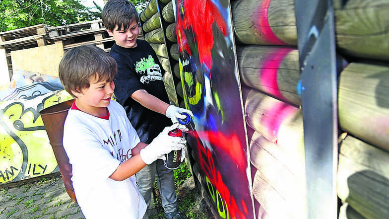 Bunt: Odin (vorn) und Arleyl probieren sich im Jugendhaus zum ersten Mal beim Graffitisprühen aus. . Foto: Sebastian Schultz