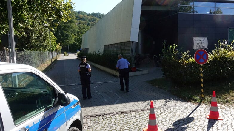 Spurensuche an der Einfahrt an der Sportschwimmhalle in Pirna: Polizisten dokumentieren im September 2023 den Unfallort.