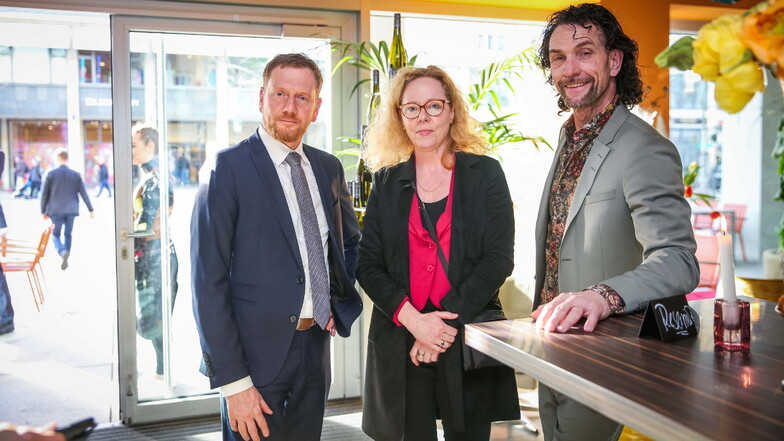 Sachsens Ministerpräsident Michael Kretschmer (l.) und die Intendantin der Dresdner Philharmonie, Frauke Roth, gratulierten dem Gastronom René Kuhnt zur Eröffnung seines neuen Kulti-Cafés Solo.