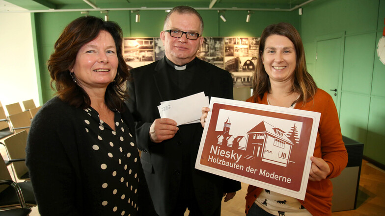 Oberbürgermeisterin Beate Hoffmann (links), Pfarrer Krystian Burczek und Claudia Wieltsch vom Wachsmannhaus sind froh, dass das Schild mithilfe von Spenden angefertigt werden kann.