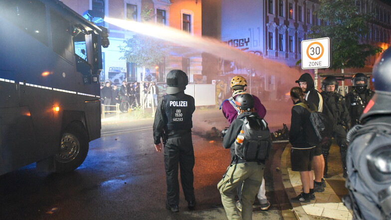 Die Polizei löschte die brennenden Barrikaden rings um das Connewitzer Kreuz mit Wasserwerfern und schob die Straßen mit gepanzerten Räumfahrzeugen frei. Zahlreiche Schaulustige standen dabei an den Straßenrändern.