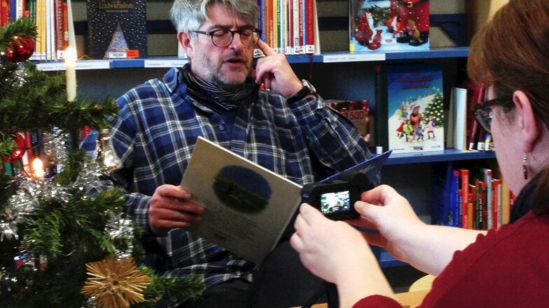 Dietmar Michaelsen (57) liest in der Brigitte-Reimann-Stadtbibliothek Hoyerswerda für den virtuellen Adventskalender eine weihnachtliche Geschichte. Presse-Arbeiterin Susann Keck „dreht“ das Video, das auf Facebook und Youtube eingestellt werden wird