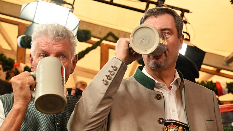 Dieter Reiter (SPD, l), Oberbürgermeister von München, und Markus Söder (CSU), Ministerpräsident von Bayern, trinken nach dem Anstich des ersten Oktoberfestfasses ihr erstes Bier des Tages.