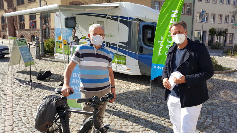 Frank Weide (links) aus Rudelsdorf ist mit seinem E-Bike zum Waldheimer Markt geradelt und unterhält sich mit Silvio Zschage vom MDR über den Radweg.