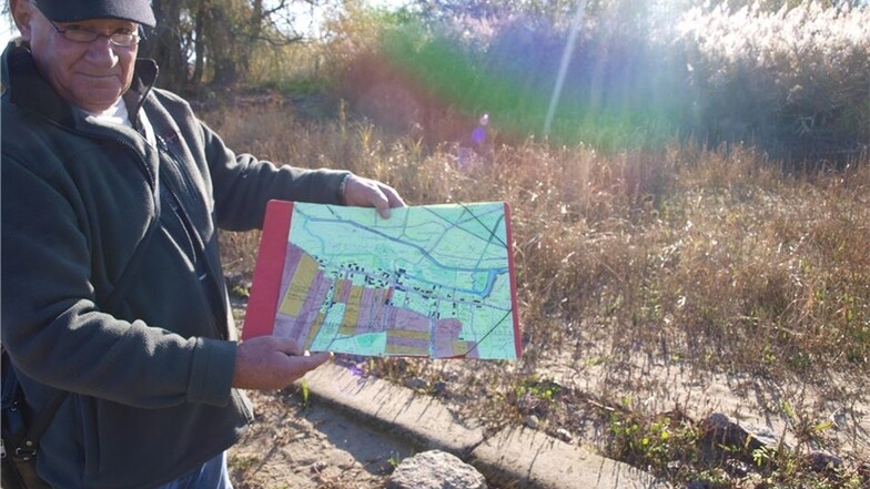 Reinhard Diekmann zeigt eine Karte des früheren Ortes Quitzdorf. Der ist 1969 abgerissen worden, um Platz für den Stausee zu schaffen.