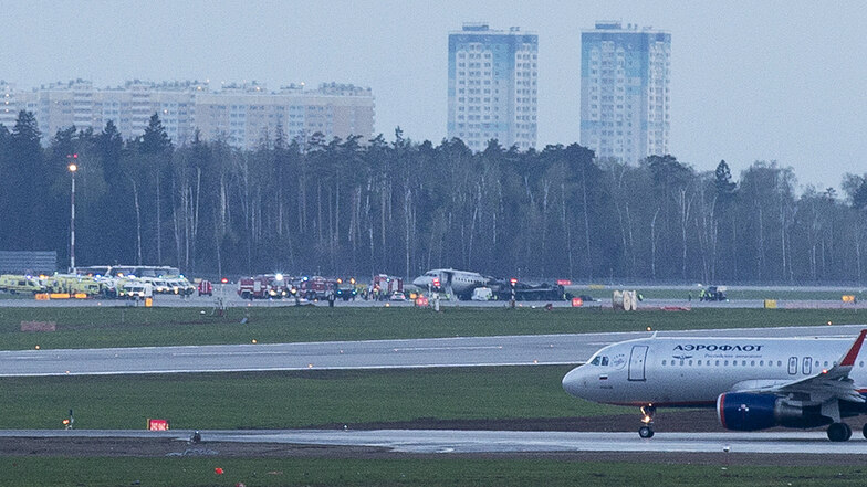 Die Unglücksmaschine steht nach Löscharbeiten auf dem Rollfeld des Flughafens Scheremetjewo und ist von Einsatzkräften umgeben. 