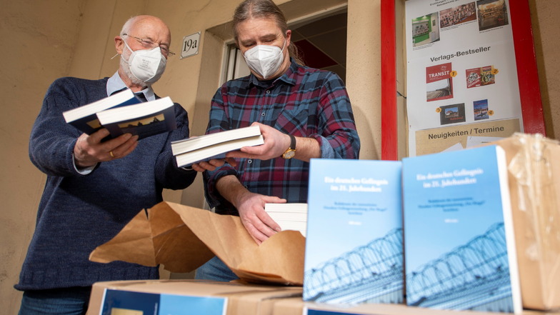Der Verleger Jens Kuhbandner (r.) und der Autor Ulfrid Kleinert packen das im Notschriftenverlag erscheinende Buch über die Dresdner Justizvollzugsanstalt am Hammerweg aus.
