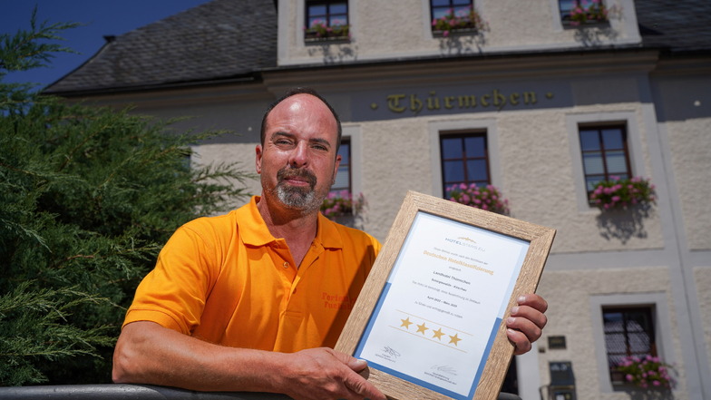 Matthias Schulze präsentiert stolz die Urkunde, mit der seinem Haus , dem Landhotel Thürmchen in Schirgiswalde, der vierte Stern verliehen wurde.