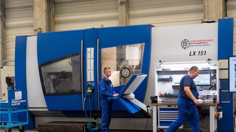 Mitarbeiter Nico Lachmann (l) bedient eine Maschine zur Fertigung von Rotorschaufeln, aufgenommen beim Besuch des Görlitzer Siemens Turbinenwerkes durch Bundespräsident Steinmeier.