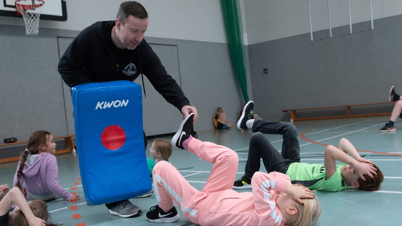 Krav-Maga-Trainer Jan Thormeyer in der Großenhainer Sporthalle am Schacht übt mit Kindern des Ferienhorts Verteidigungstechniken.