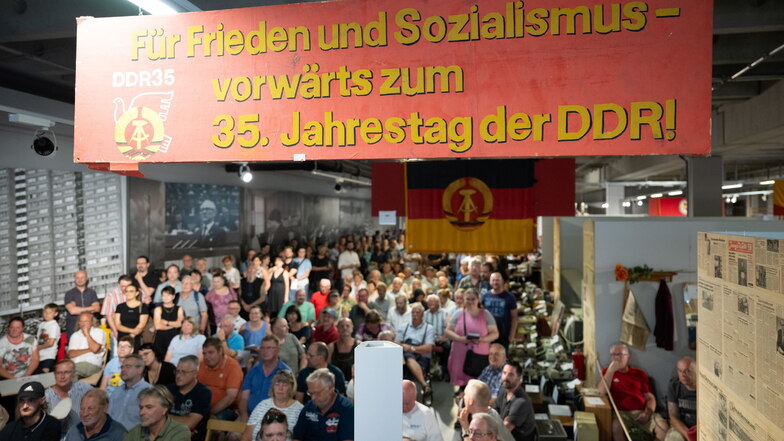 Die DDR war ein Teil ihres Lebens: Teilnehmer stehen und sitzen während einer Versteigerung in den Ausstellungsräumen des bereits geschlossenen Dresdner Museums "Welt der DDR"· und bieten um "Erinnerungsstücke".