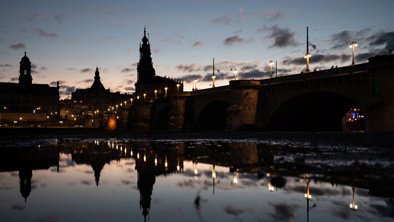 Die Dresdner Augustusbrücke hat zumindest einen Teil der Beleuchtung an, vieles andere bleibt im Dunkeln.