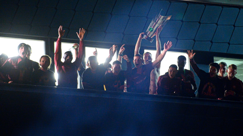 Sebastian Mai präsentiert den Fans vor dem Trainingszentrum nach dem Gewinn der Drittliga-Meisterschaft und der Ankunft aus Wiesbaden den Pokal.