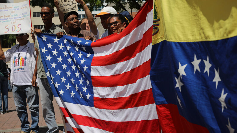 Politische Gegner des venezolanischen Präsidenten Maduro halten Flaggen der USA und Venezuelas.