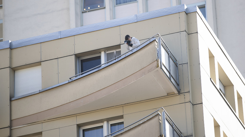 Ein Kriminalpolizist macht auf einem Balkon eines Wohnhauses, in dem aus einer Wohnung mehrere Menschen in den Tod gesprungen sind, Fotos. Fünf Angehörige einer Familie haben sich vom Balkon des Wohnhauses gestürzt.