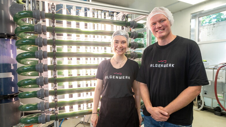 Gunnar Mühlstädt, Geschäftsführer vom Algenwerk in Dresden, und Antonia Bätzold vom Marketing stehen vor den Anlagen, in denen Algen wachsen. Die Spirulina gibt es frisch abgezapft in Gläsern - und bald auch als Wassereis.