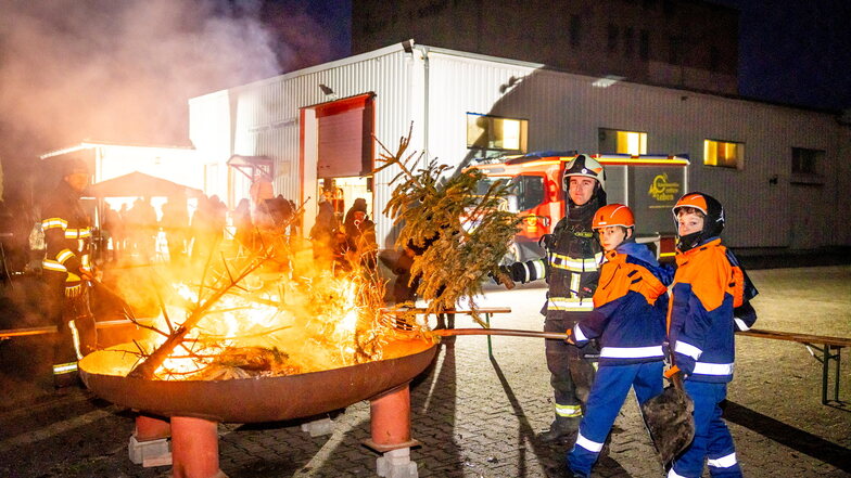 Ab ins Feuer: Beim Weihnachtsbaumleuchten der Freiwilligen Feuerwehr Birkwitz-Pratzschwitz hatte Feuerwehrmann Marco Reimann zusammen mit  Philipp (re.) und Bruno ein wachsames Auge auf die Flammen.