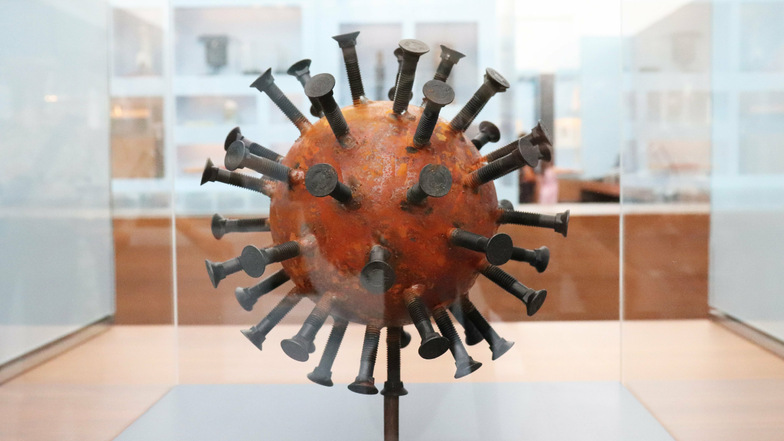 Diese rostfarbene Kugel mit Nägeln symbolisiert das Coronavirus.
