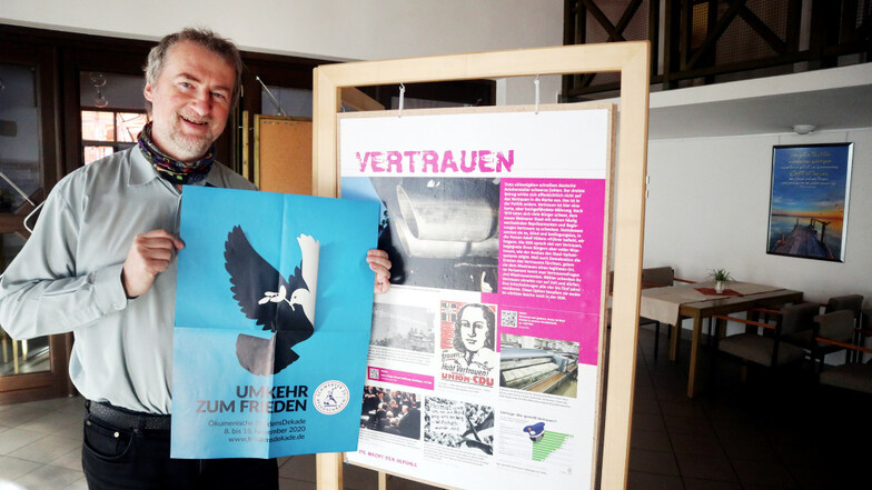 Pfarrer Jörg Michel zeigt im Martin-Luther-King-Haus Hoyerswerda das Plakat zur diesjährigen 40. Ökumenischen Friedensdekade. Foto: Andreas Kirschke