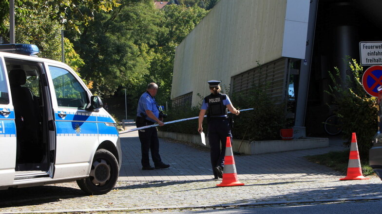 Einfahrt an der Sportschwimmhalle Pirna: Polizisten dokumentieren den Unfallort.