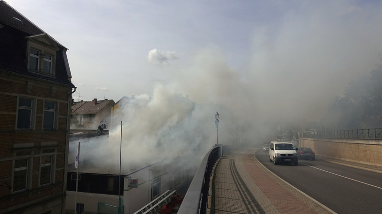 Rauch über der Stadtbrücke. Am Freitagvormittag drohte ein Feuer an der Stadtbrücke auf ein Mehrfamilienhaus überzugreifen.