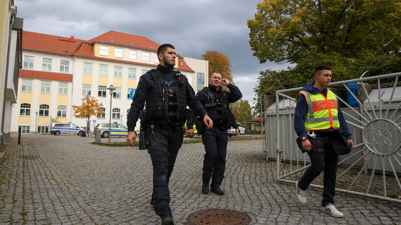 Polizeibeamte durchsuchten nach einer Bombendrohung die Grund- und Oberschule in Pulsnitz. Sie sicherten das Gelände großräumig ab.