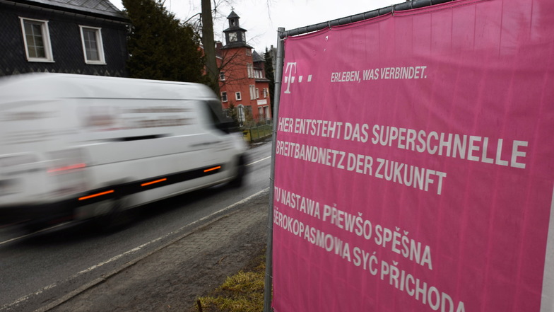 Ein Banner der Telekom weist auf die Verlegung von Breitbandkabeln in Steinigtwolmsdorf hin. Doch einige Einwohner warten bis heute auf schnelles Internet.