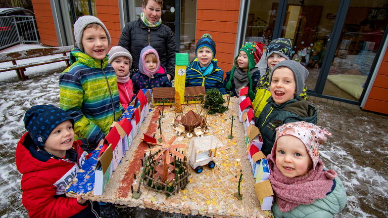 Stolz zeigen die Kinder das Modell des Waldheimer Weihnachtsmarktes, das sie mir ihrer Erzeiherin Susan Speck gebaut haben. Sie gewannen damit den Wettbewerb der VR-Bank Mittelsachsen.