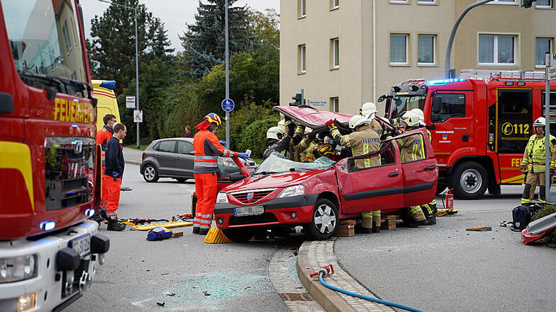 Unfall in Bautzen am späten Freitagnachmittag auf der Kreuzung Neusalzaer/Zeppelinstraße: Feuerwehrleute schneiden das Dach eines Dacia ab, um den eingeklemmten Fahrer zu befreien.