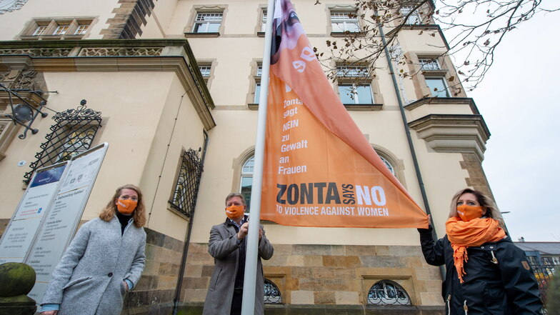 Oberbürgermeister Bert Wendsche (M.) hisste mit Katja Kulisch (l.) und Svenja Sprößig die orange Fahne der Aktion "Zonta sagt nein" zu Gewalt gegen Frauen vor dem Rathaus.