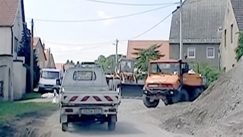 Hier schoben sich im Juni 2013 große und kleine Baufahrzeuge durch, um für Sandsack-Nachschub aus der Dorfmitte zu sorgen. Darunter hat die Straße gelitten.