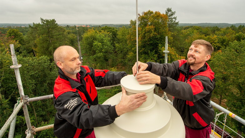 Nachdem die Vase auf dem Dach befestigt ist, bringen Frank Neubert (re.) und Jan Hett den Blitzableiter an.