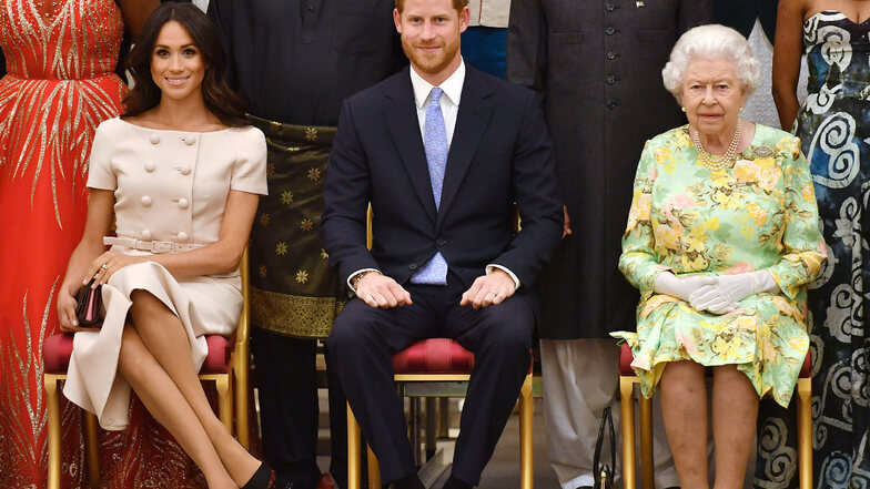 Die britische Königin Elizabeth II. (r), Prinz Harry und dessen Frau Meghan nehmen an den Queen's Young Leaders Awards teil. Das Paar darf vom Frühjahr an seinen Markennamen "Sussex Royal" nicht mehr benutzen.