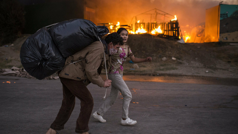Migranten fliehen vor neu ausgebrochenen Feuern mit ihren Habseligkeiten aus dem Flüchtlingslager Moria, nachdem zuvor bereits mehrere Brände das Lager nahezu vollständig zerstört hatten.