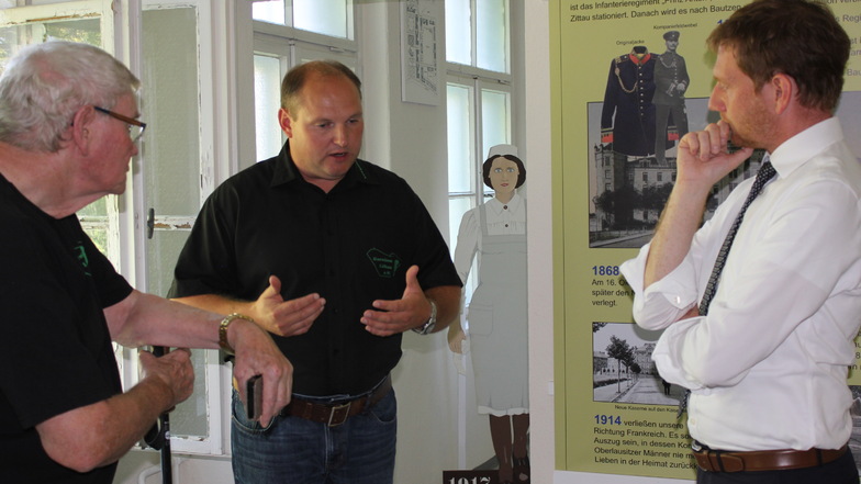 Garnisonverein-Vorsitzender Danilo Baumgarten (Mitte) führte Ministerpräsident Michael Kretschmer (r.) durch das Vereinsmuseum.