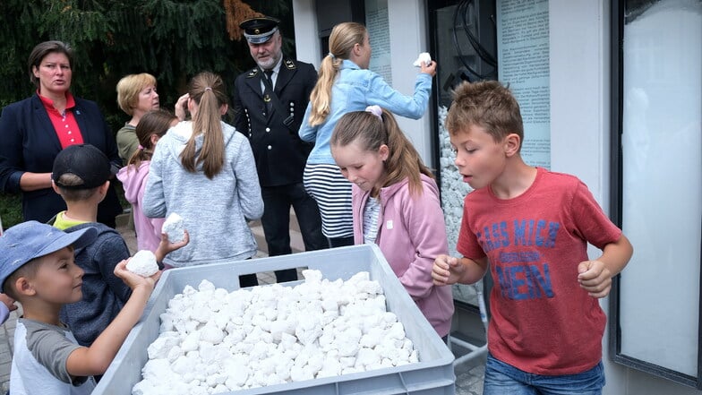 Kinder aus dem Hort der Questenbergschule befüllten Vitrinen mit Kaolin. Steiger Andreas Kawka und Inga Skambraks vom Stadtplanungsamt waren auch dabei.