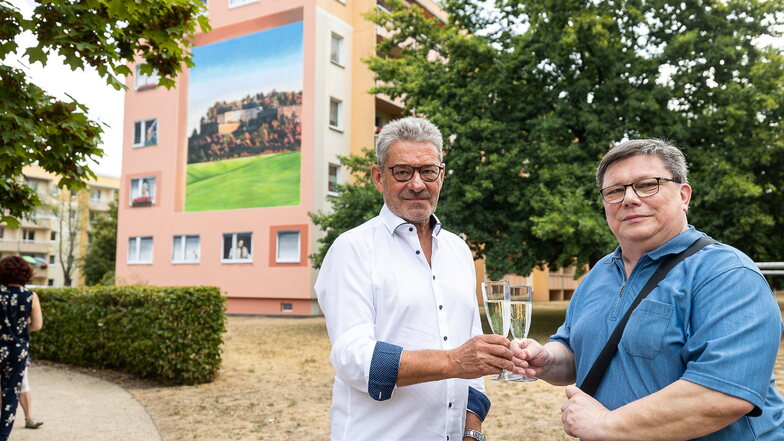 Pirnas Oberbürgermeister Klaus-Peter Hanke (li.) und WGP-Geschäftsführer Jürgen Scheible stoßen auf das neue Wandbild auf dem Sonnenstein an.