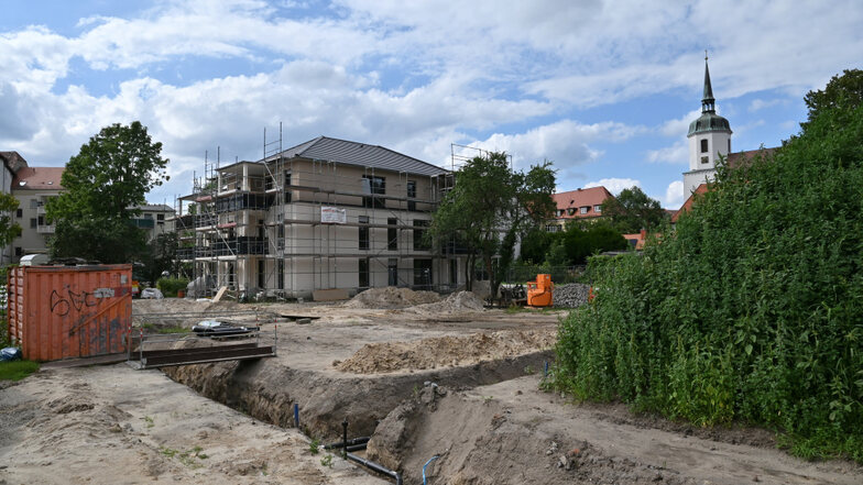 Das erste Haus im Quartier an der Bleichwiese steht, in den Gräben im Vordergrund werden die Fernwärmeleitungen verlegt.