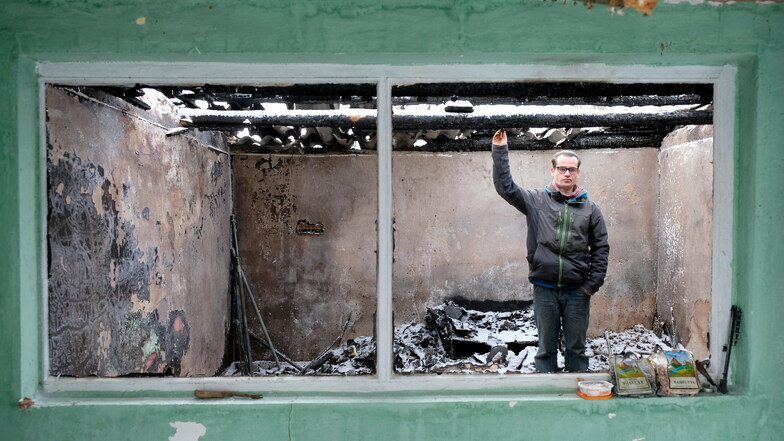 Mike Schneider zeigt auf das Dach der Laube, an dem der Brand ausgebrochen ist. Das Feuer griff auf den Hühnerstall über.